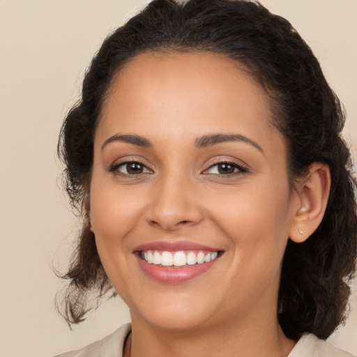 Joyful latino young-adult female with medium  brown hair and brown eyes