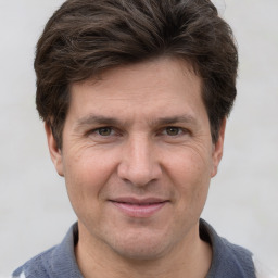 Joyful white adult male with short  brown hair and grey eyes