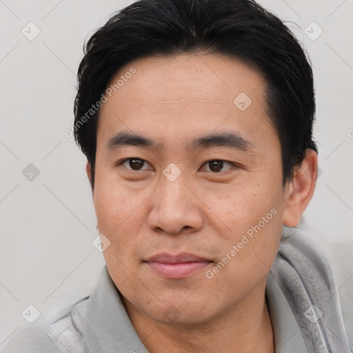 Joyful asian young-adult male with short  brown hair and brown eyes