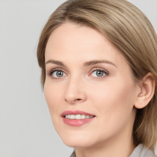 Joyful white young-adult female with medium  brown hair and grey eyes