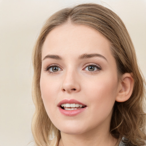 Joyful white young-adult female with long  brown hair and blue eyes