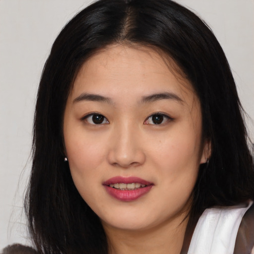 Joyful asian young-adult female with long  brown hair and brown eyes