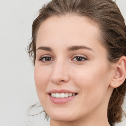 Joyful white young-adult female with medium  brown hair and grey eyes