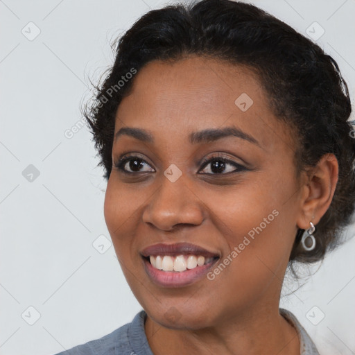 Joyful black young-adult female with long  black hair and brown eyes