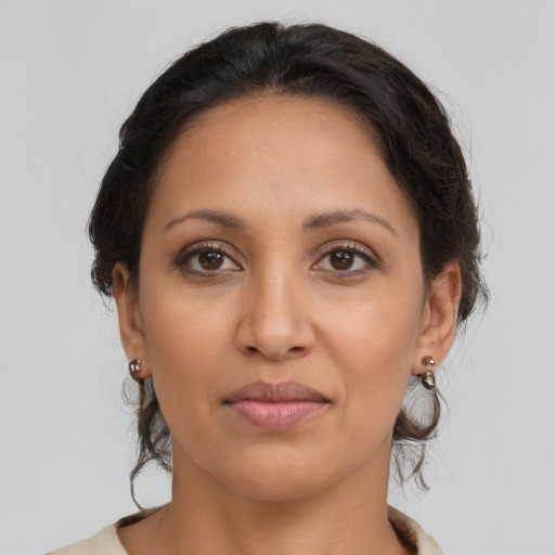 Joyful latino adult female with medium  brown hair and brown eyes