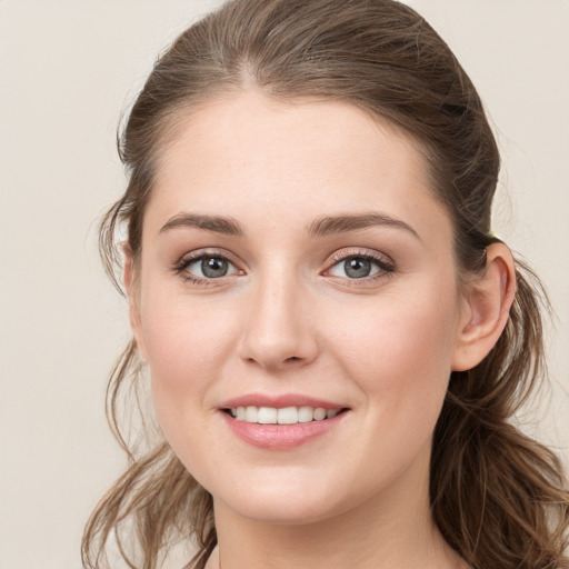 Joyful white young-adult female with long  brown hair and grey eyes