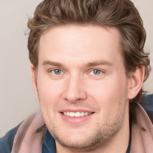 Joyful white young-adult male with short  brown hair and blue eyes