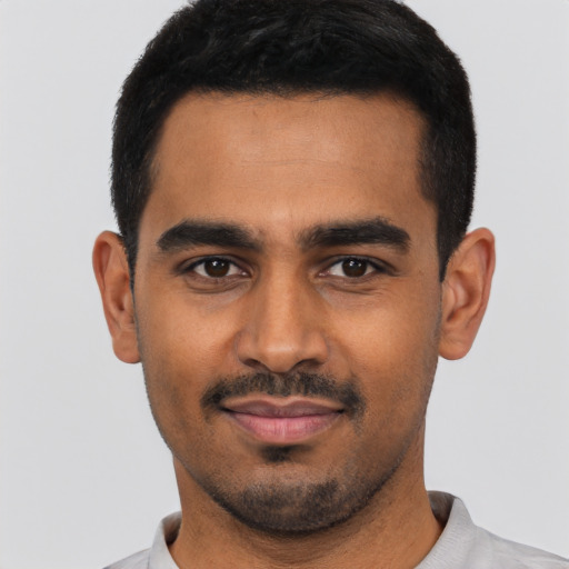 Joyful latino young-adult male with short  black hair and brown eyes