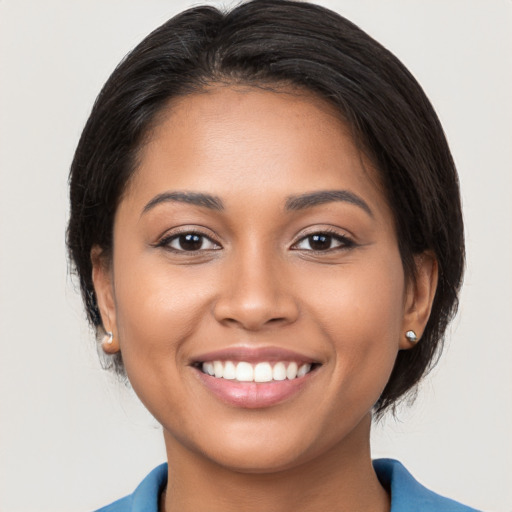 Joyful latino young-adult female with medium  black hair and brown eyes