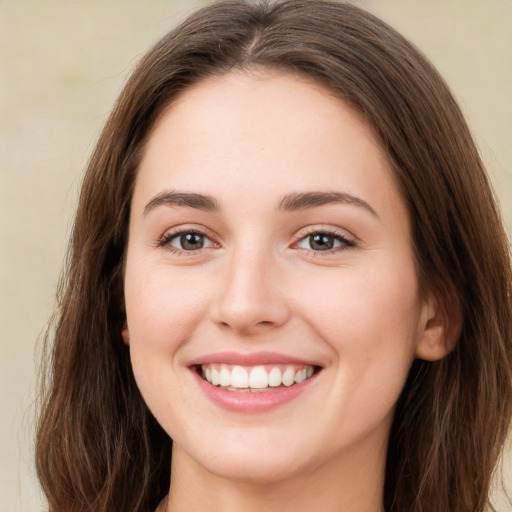 Joyful white young-adult female with long  brown hair and green eyes