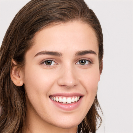 Joyful white young-adult female with long  brown hair and brown eyes