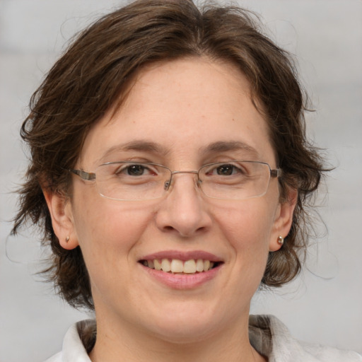 Joyful white adult female with medium  brown hair and green eyes