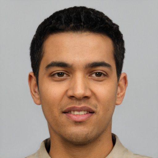 Joyful latino young-adult male with short  black hair and brown eyes