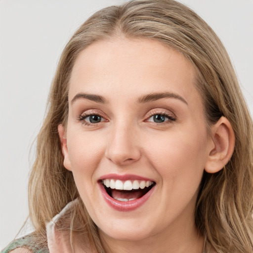 Joyful white young-adult female with long  brown hair and blue eyes