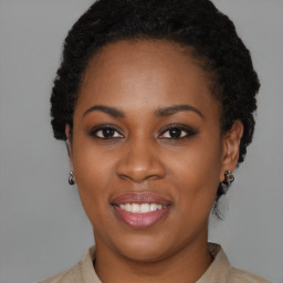 Joyful black young-adult female with short  brown hair and brown eyes