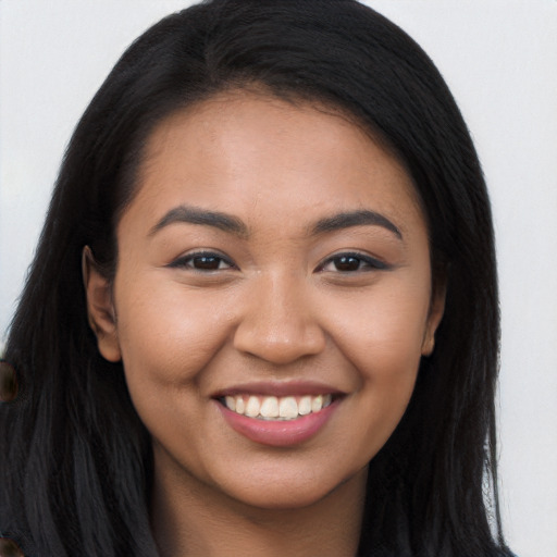 Joyful latino young-adult female with long  brown hair and brown eyes