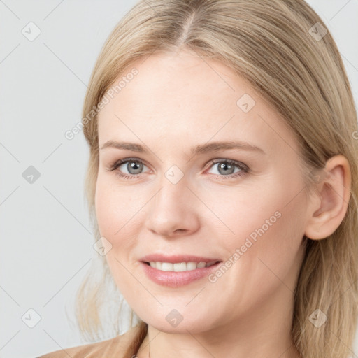 Joyful white young-adult female with long  brown hair and blue eyes