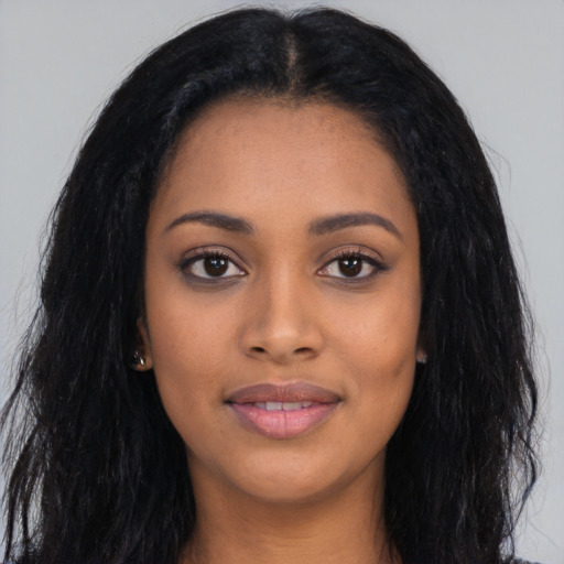 Joyful black young-adult female with long  black hair and brown eyes