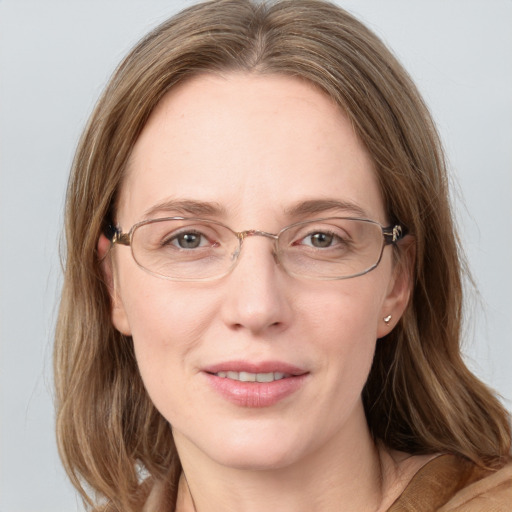 Joyful white adult female with medium  brown hair and blue eyes