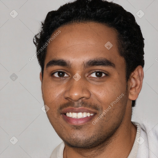Joyful black young-adult male with short  black hair and brown eyes
