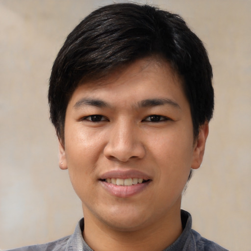 Joyful asian young-adult male with short  black hair and brown eyes