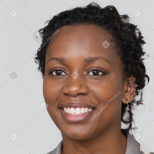 Joyful black young-adult female with long  brown hair and brown eyes