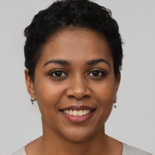 Joyful black young-adult female with short  black hair and brown eyes