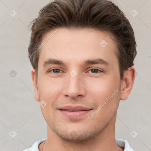 Joyful white young-adult male with short  brown hair and grey eyes