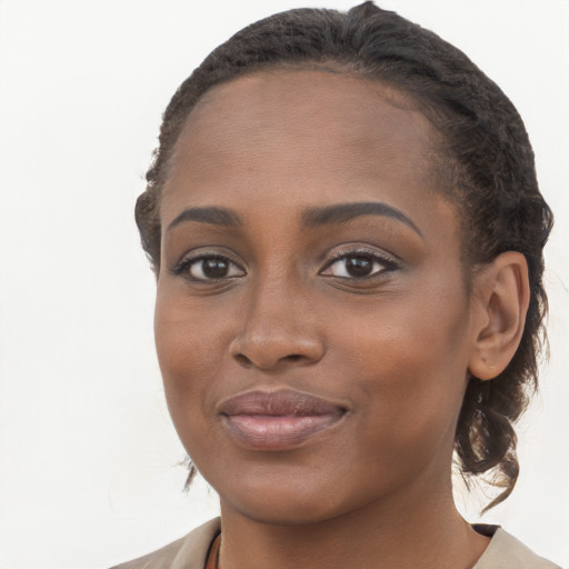 Joyful black young-adult female with long  brown hair and brown eyes