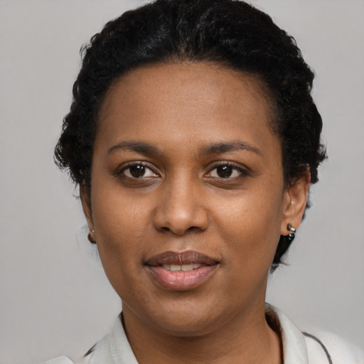 Joyful black young-adult female with short  black hair and brown eyes