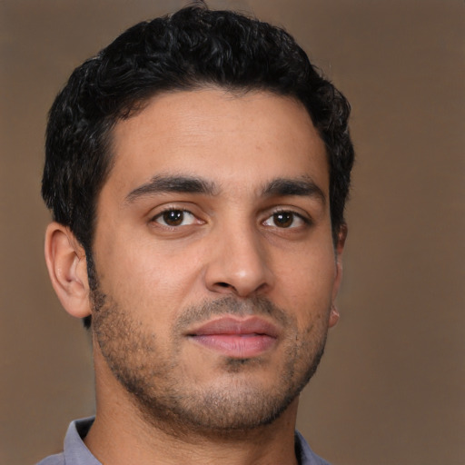 Joyful latino young-adult male with short  brown hair and brown eyes