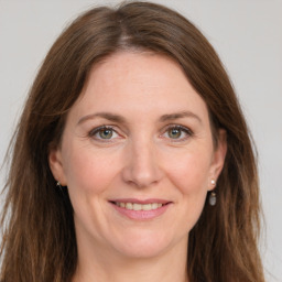 Joyful white adult female with long  brown hair and grey eyes