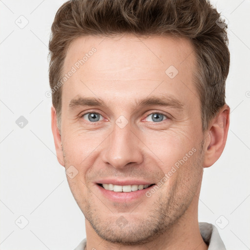 Joyful white young-adult male with short  brown hair and grey eyes