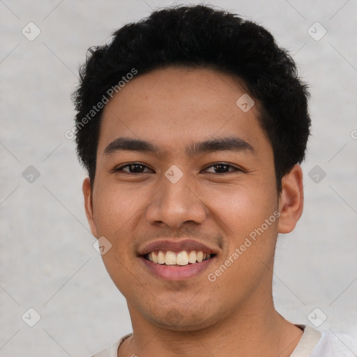 Joyful latino young-adult male with short  black hair and brown eyes