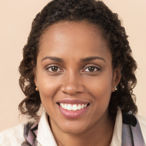 Joyful black young-adult female with long  brown hair and brown eyes