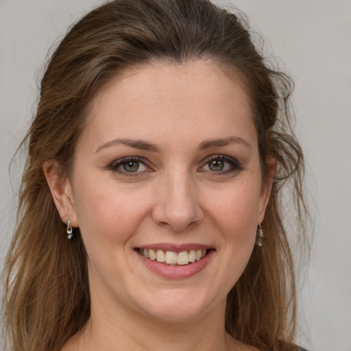 Joyful white young-adult female with long  brown hair and grey eyes