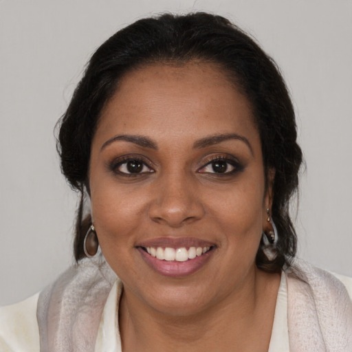 Joyful black young-adult female with long  brown hair and brown eyes