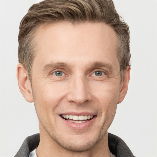 Joyful white adult male with short  brown hair and grey eyes