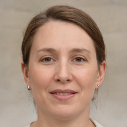 Joyful white adult female with medium  brown hair and grey eyes