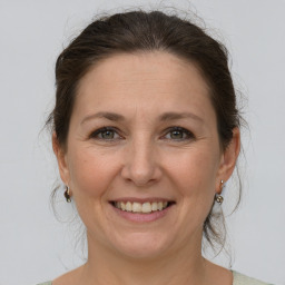 Joyful white adult female with medium  brown hair and grey eyes