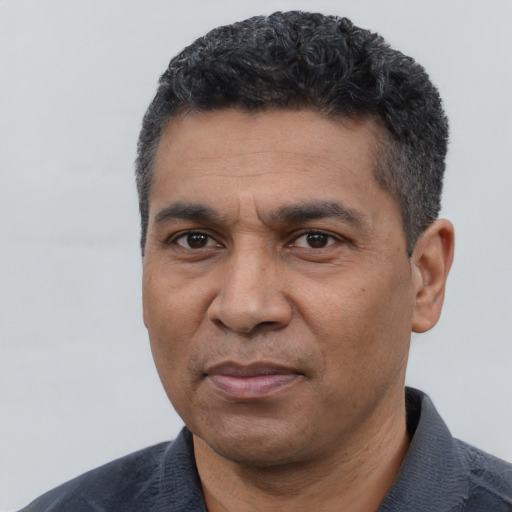 Joyful black adult male with short  black hair and brown eyes