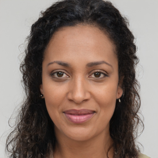 Joyful black young-adult female with long  brown hair and brown eyes