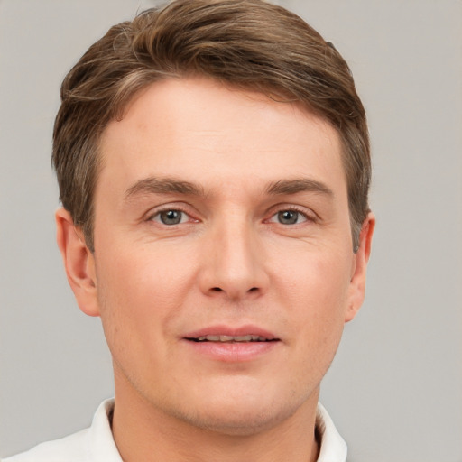 Joyful white young-adult male with short  brown hair and grey eyes