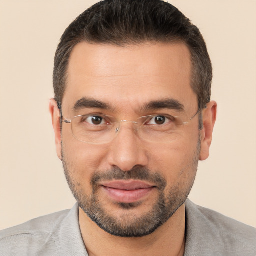 Joyful white adult male with short  black hair and brown eyes