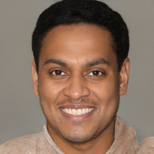 Joyful latino young-adult male with short  black hair and brown eyes