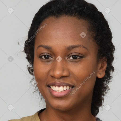 Joyful black young-adult female with long  brown hair and brown eyes