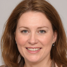 Joyful white adult female with medium  brown hair and grey eyes