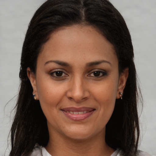 Joyful latino young-adult female with long  brown hair and brown eyes