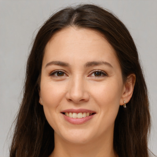 Joyful white young-adult female with long  brown hair and brown eyes