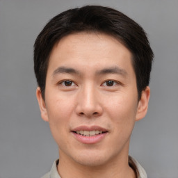 Joyful asian young-adult male with short  brown hair and brown eyes